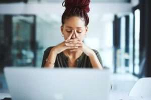 Woman upset sitting in front of computer