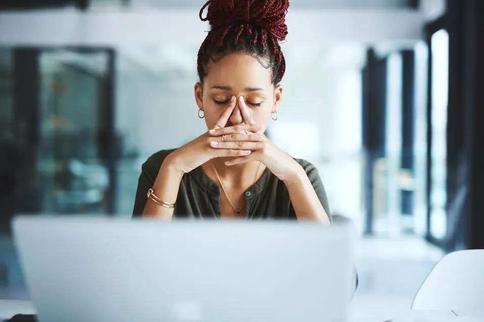 Woman upset sitting in front of computer