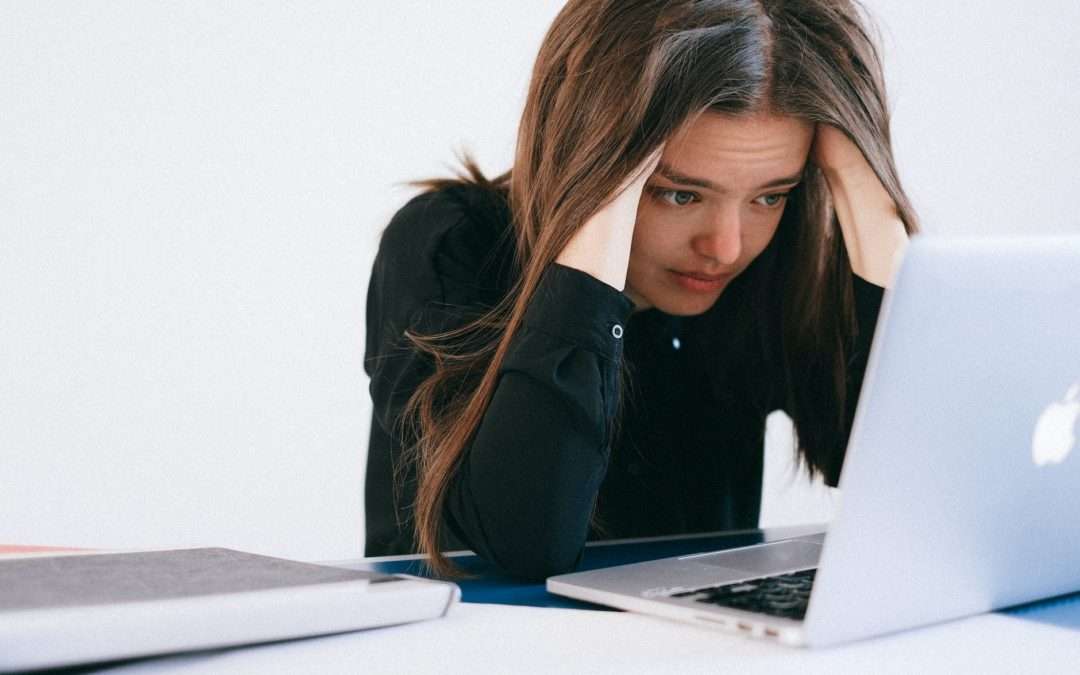 stressed woman looking at a laptop