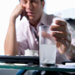 Businessman,In,Office,With,Headache,Dissolving,Tablets,In,Glass,Of